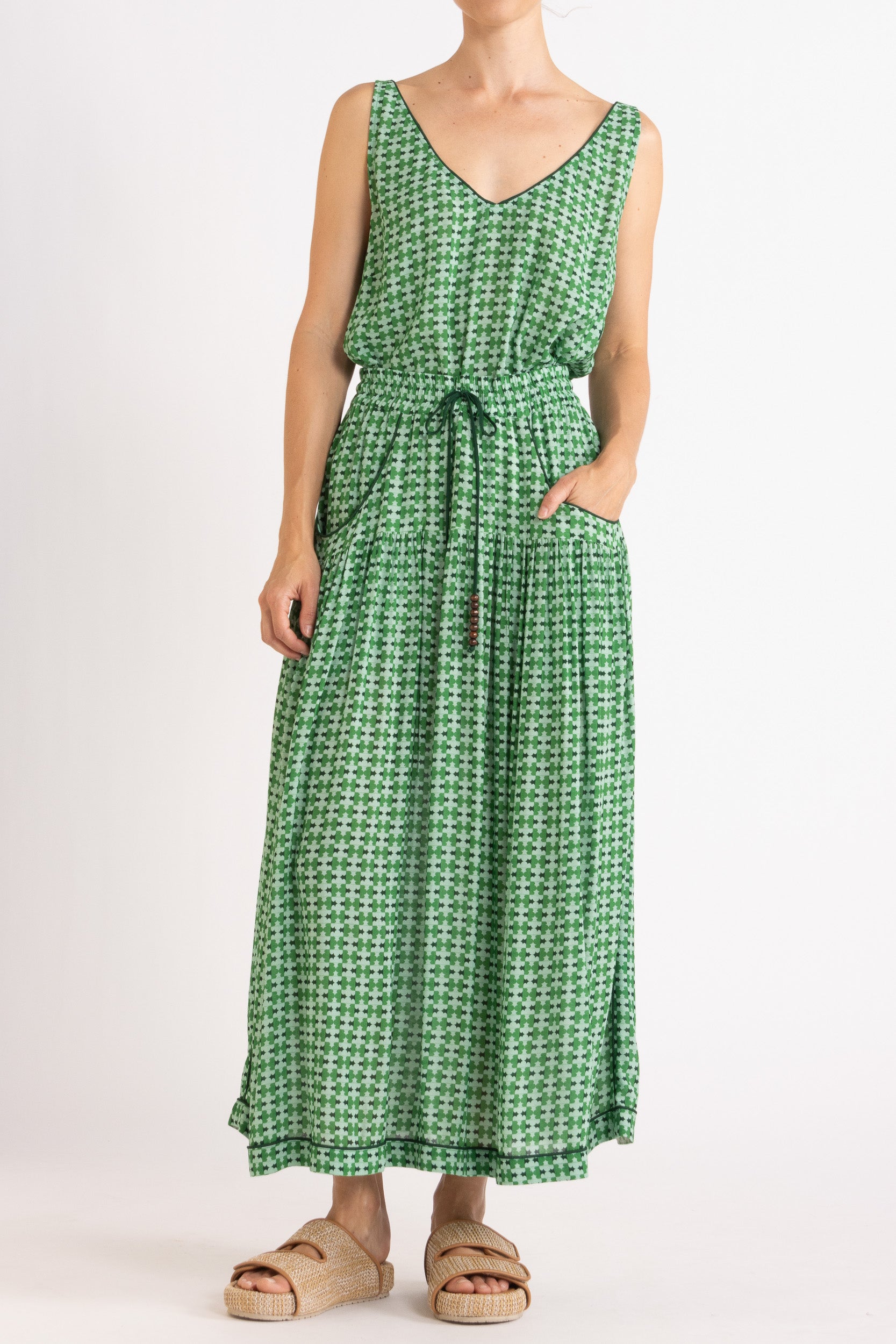 Model wearing green patterned tank and skirt, front view