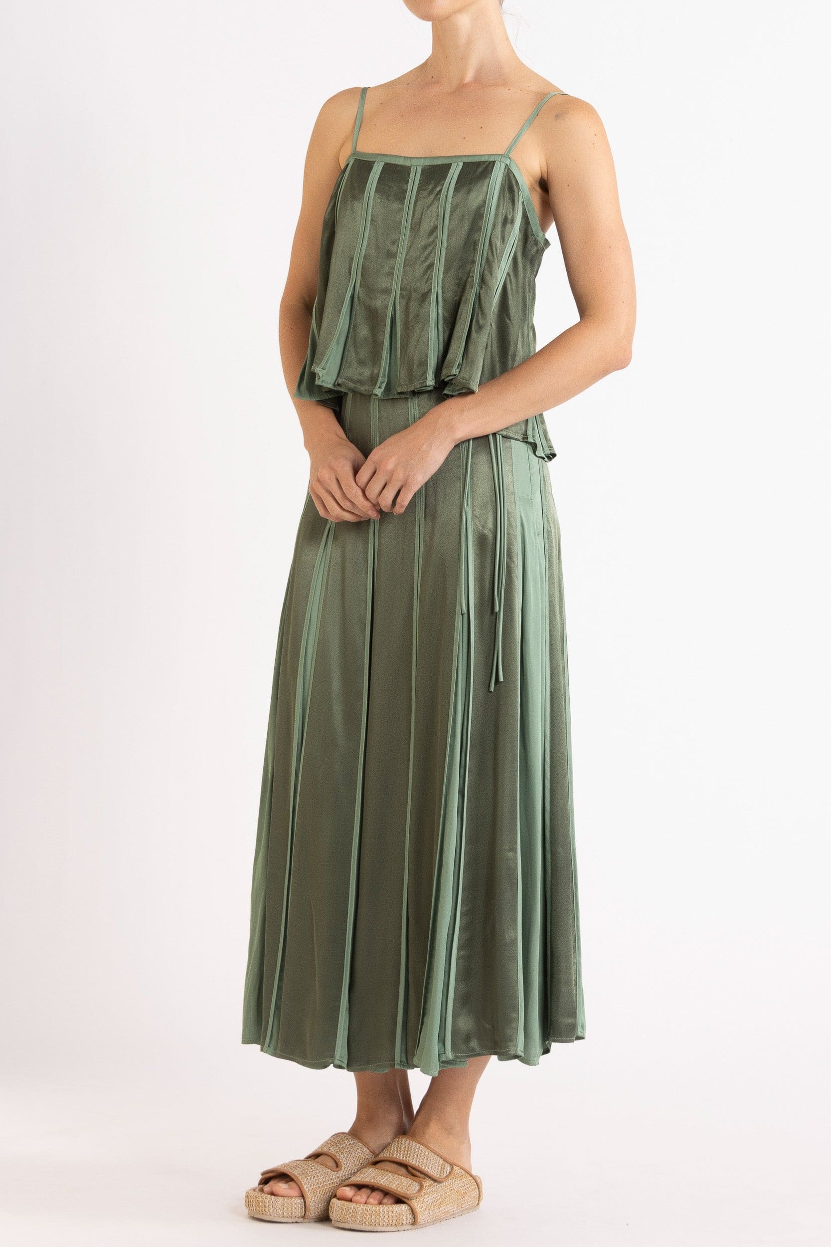 Model wearing olive green box pleat camisole & skirt, front-side view