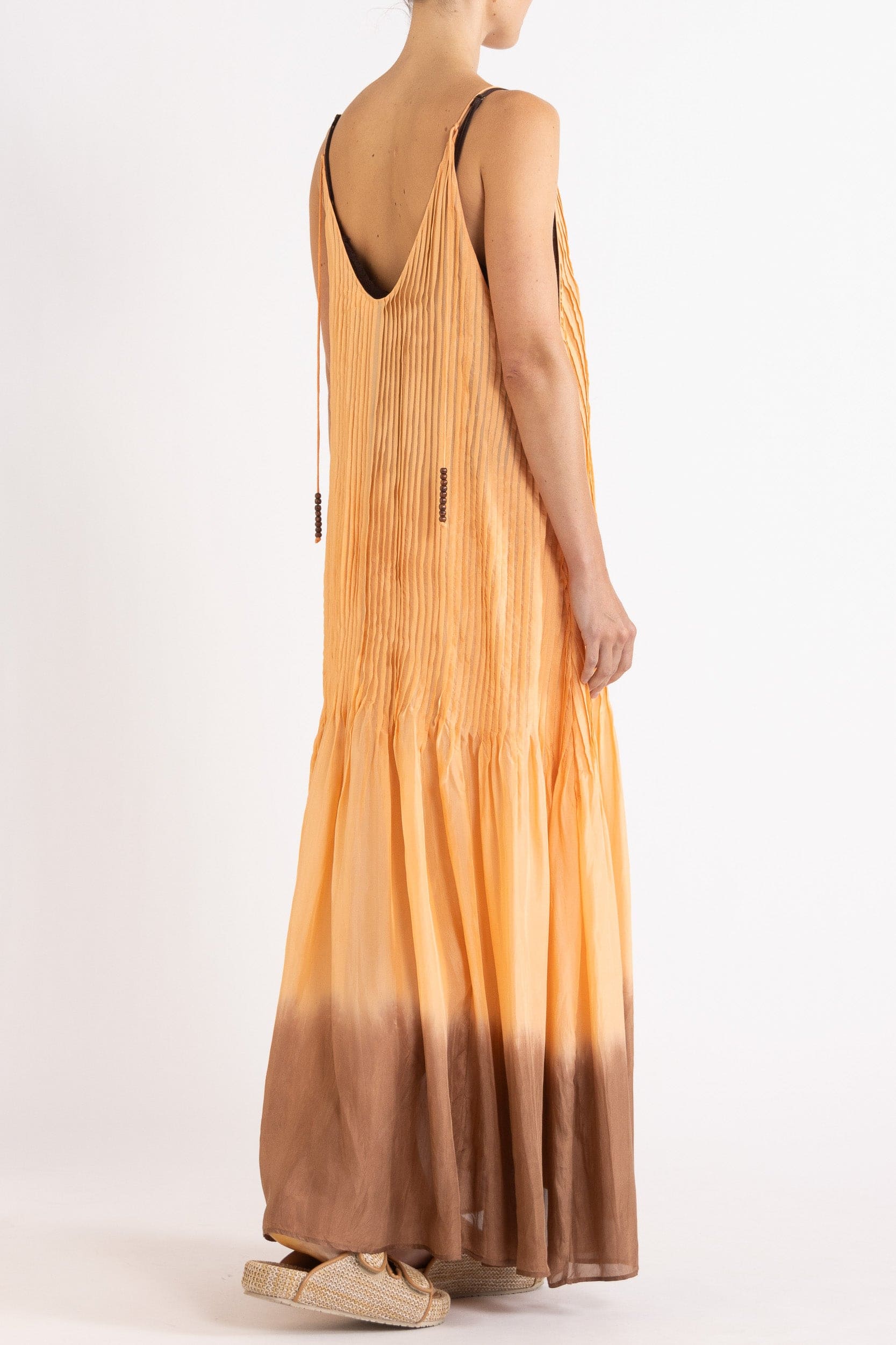 Model wearing peach dip-dye silk cami dress, back-side view