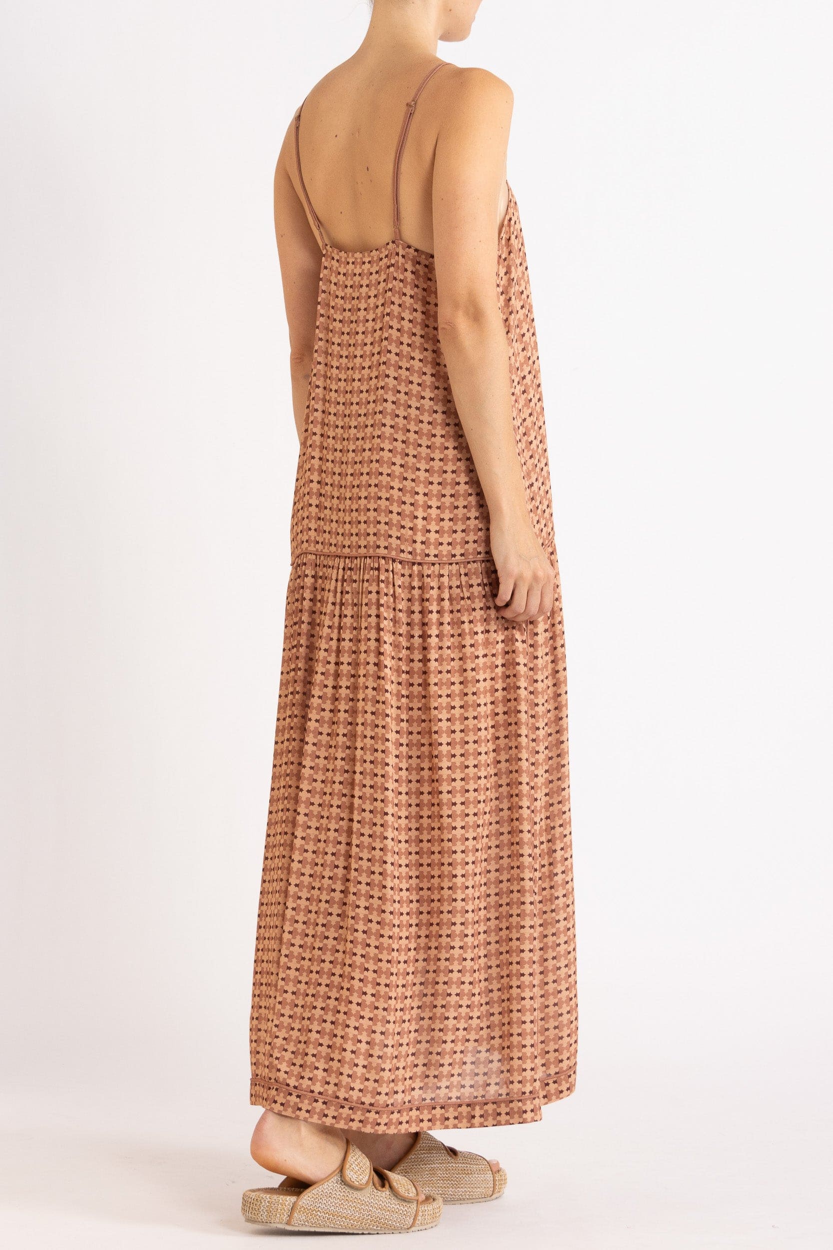 Model wearing peach patterned dress, side-back view