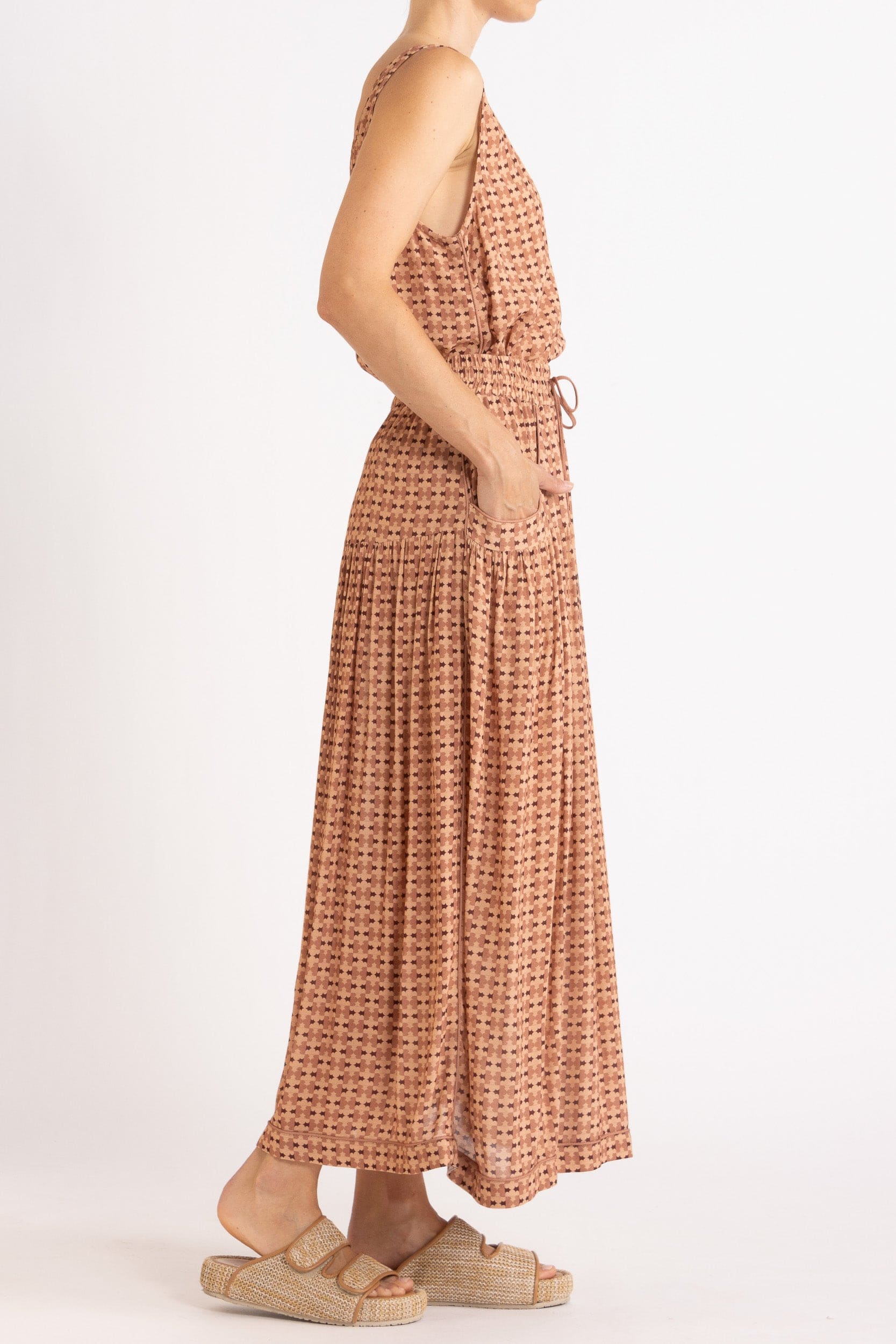 Model wearing peach patterned tank and skirt, side view