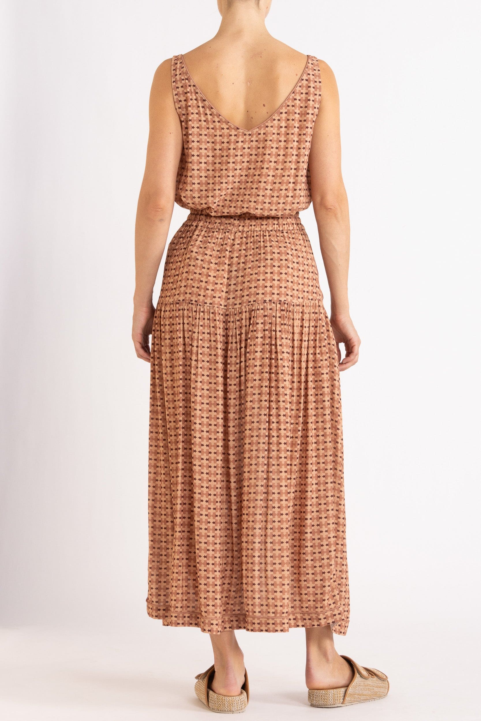 Model wearing peach print tank and skirt, back view