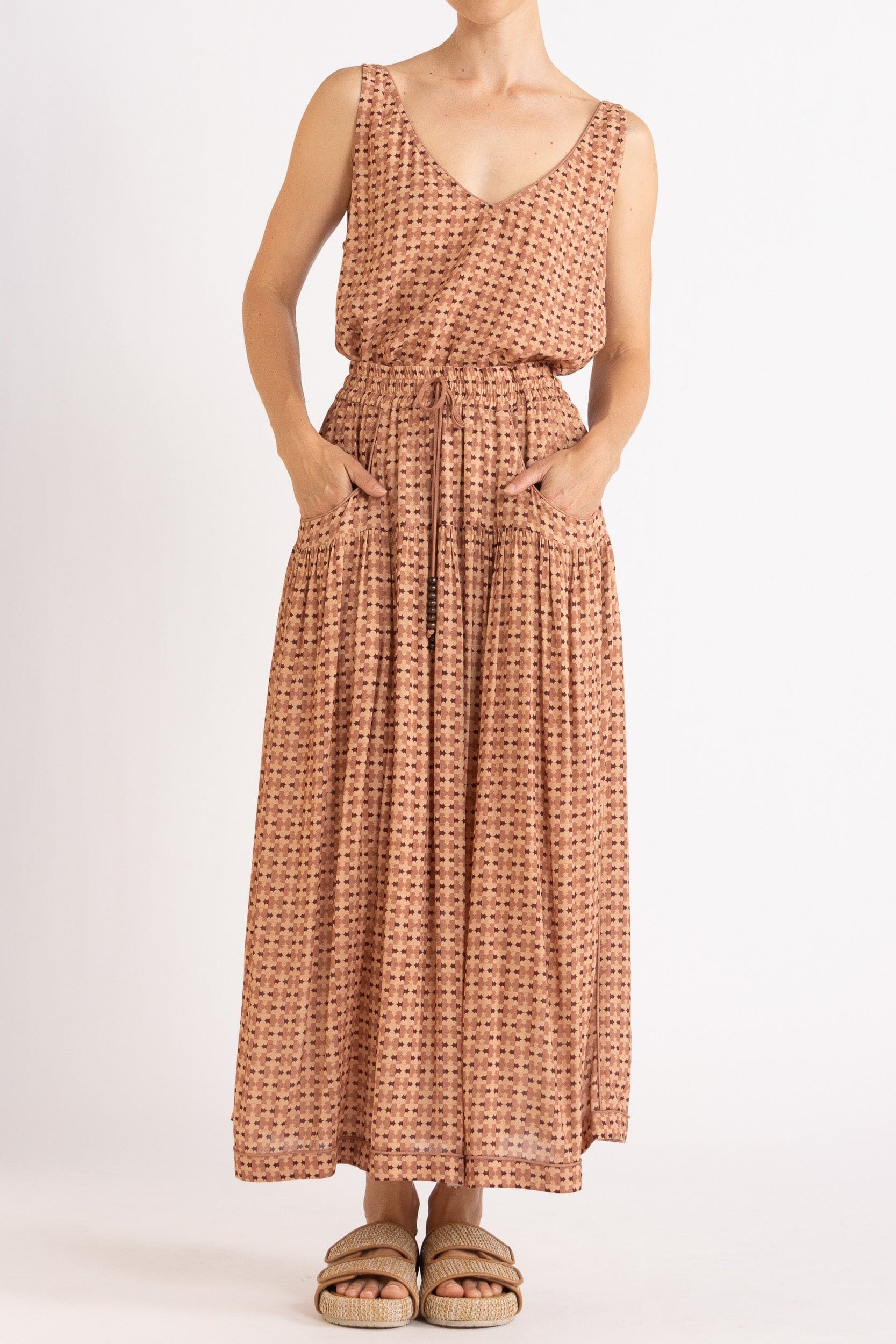 Model wearing peach patterned tank and skirt, front view