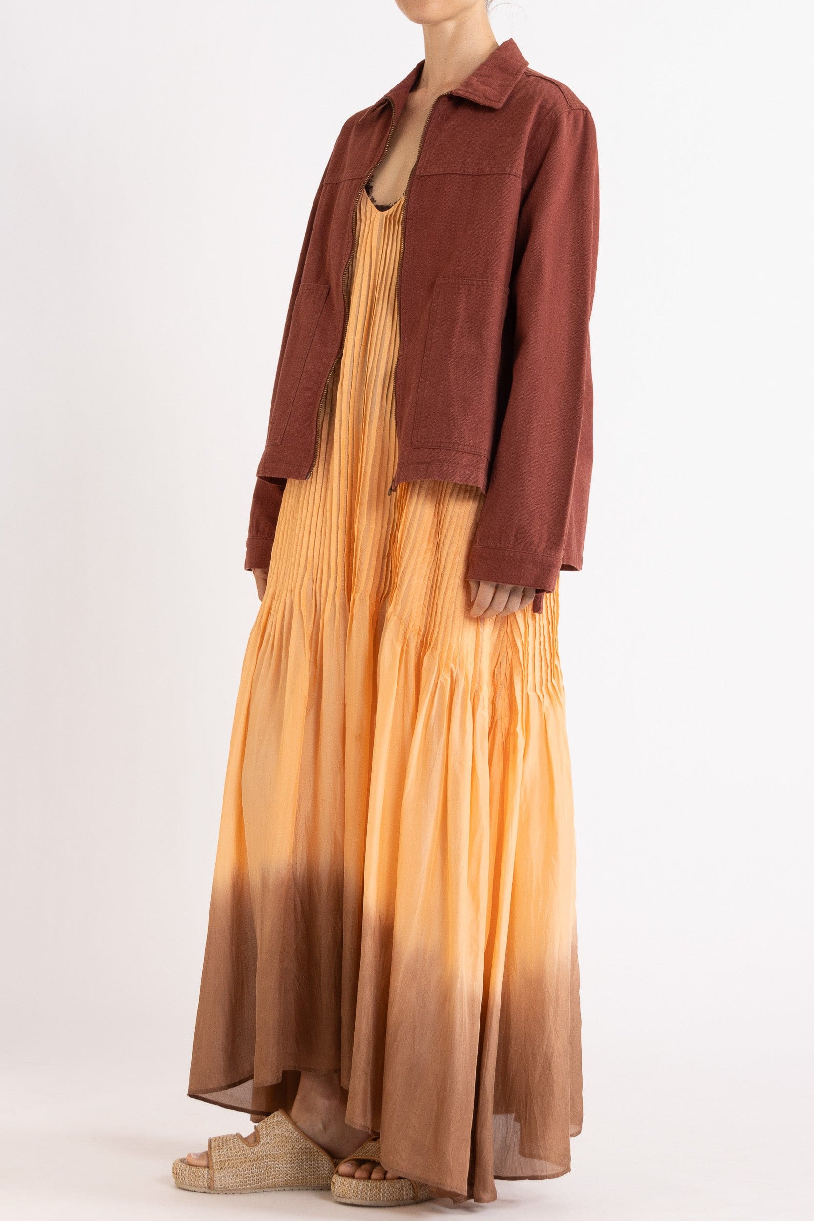 Model wearing burgundy cotton-twill utility jacket & peach dip-dye silk dress, side-front view