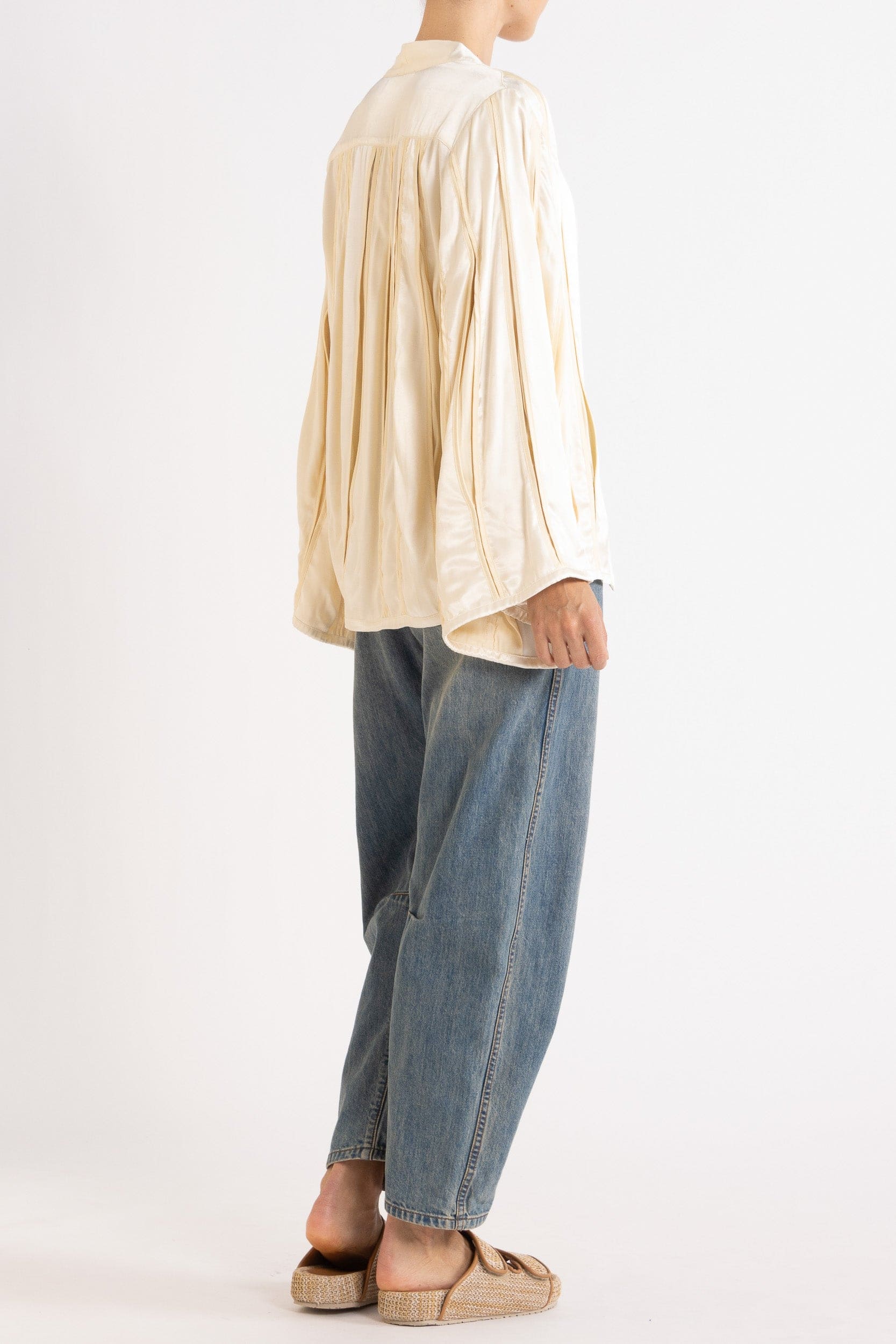 Model wearing cream box pleat jacket, white lace camisole & denim jean, side-back view