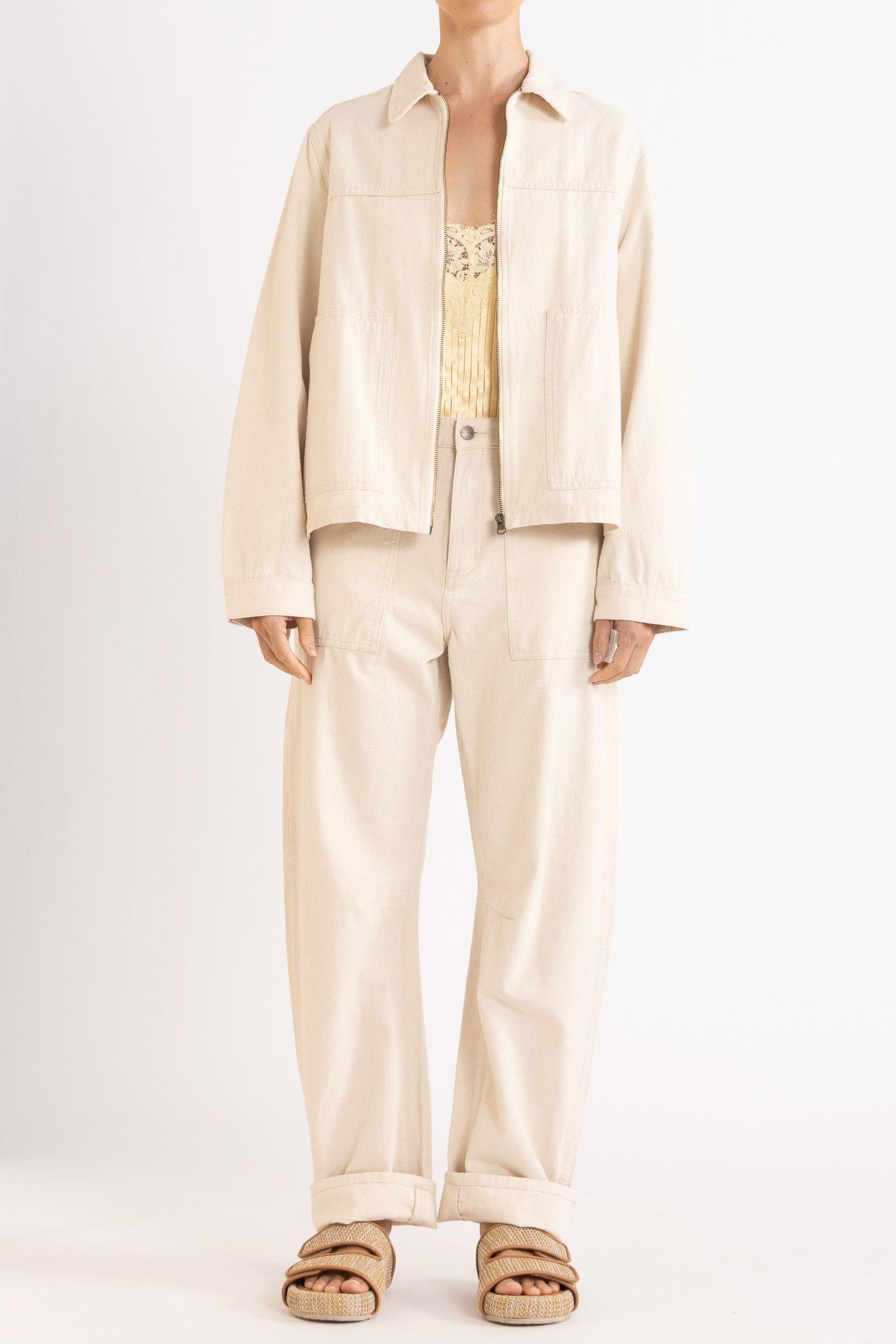 Model wearing cream cotton-twill utility jacket, pale yellow satin cami with lace trims & cream cotton-twill pant, front view