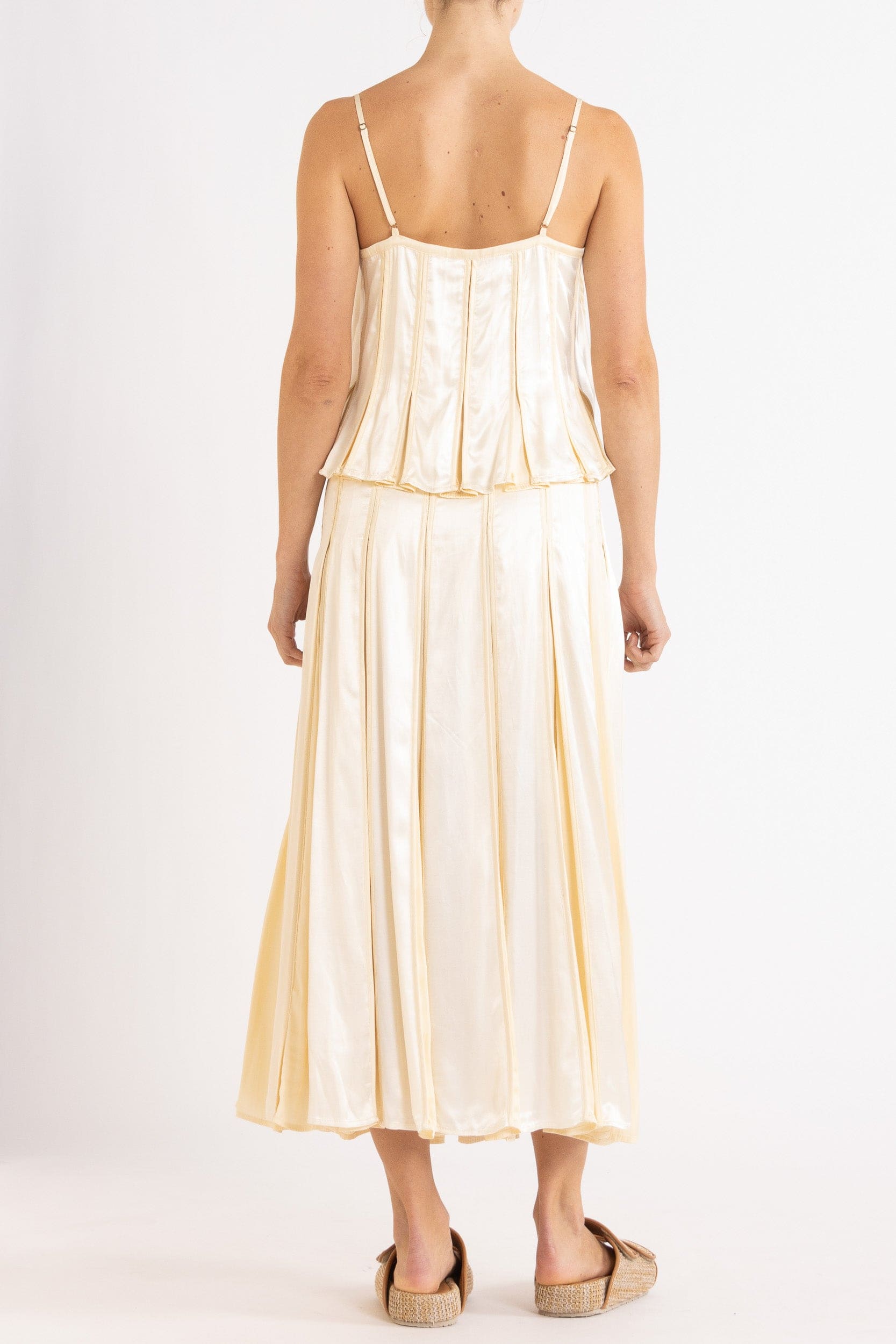 Model wearing cream box pleat camisole & skirt, back view