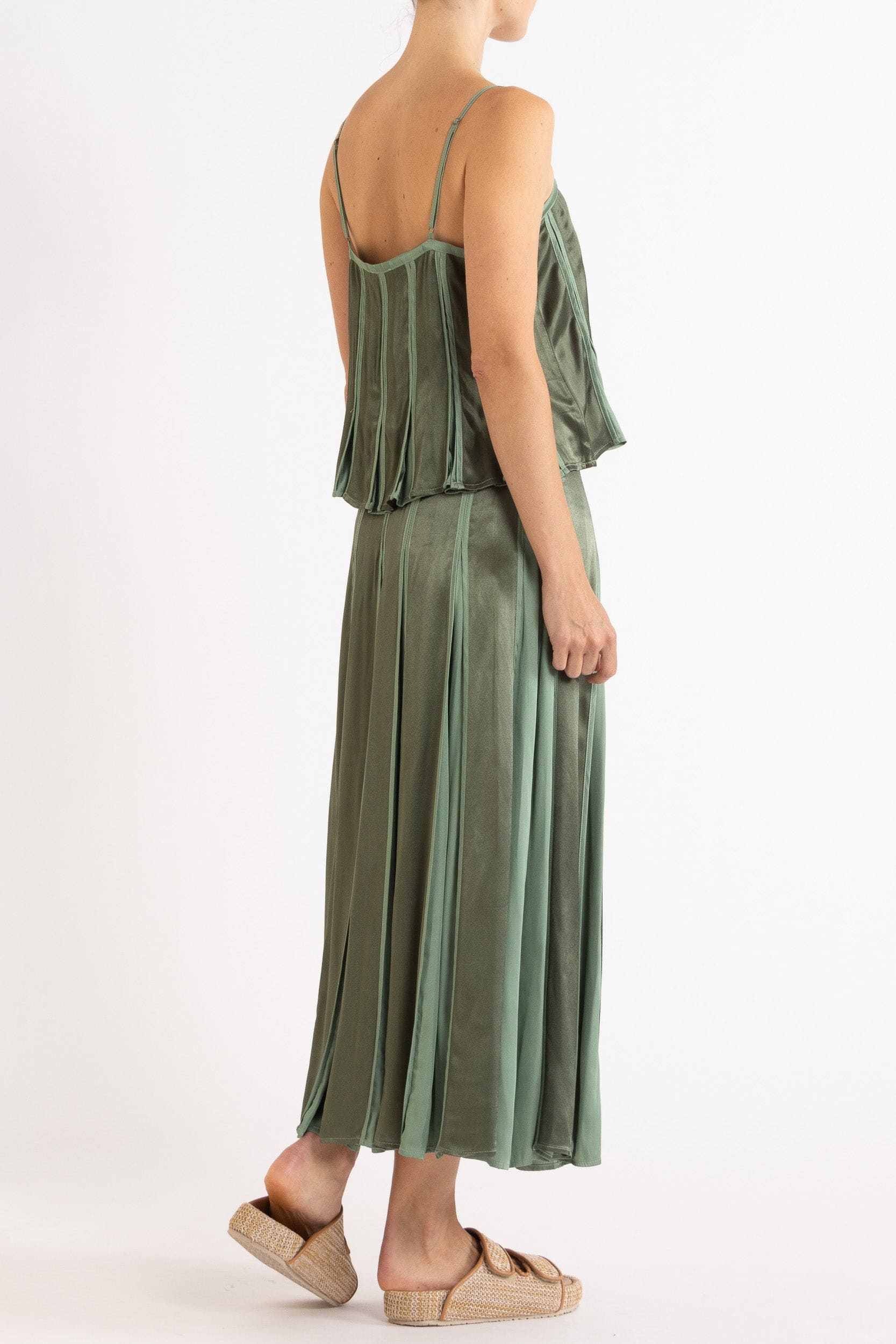 Model wearing olive green box pleat camisole & skirt, side-back view