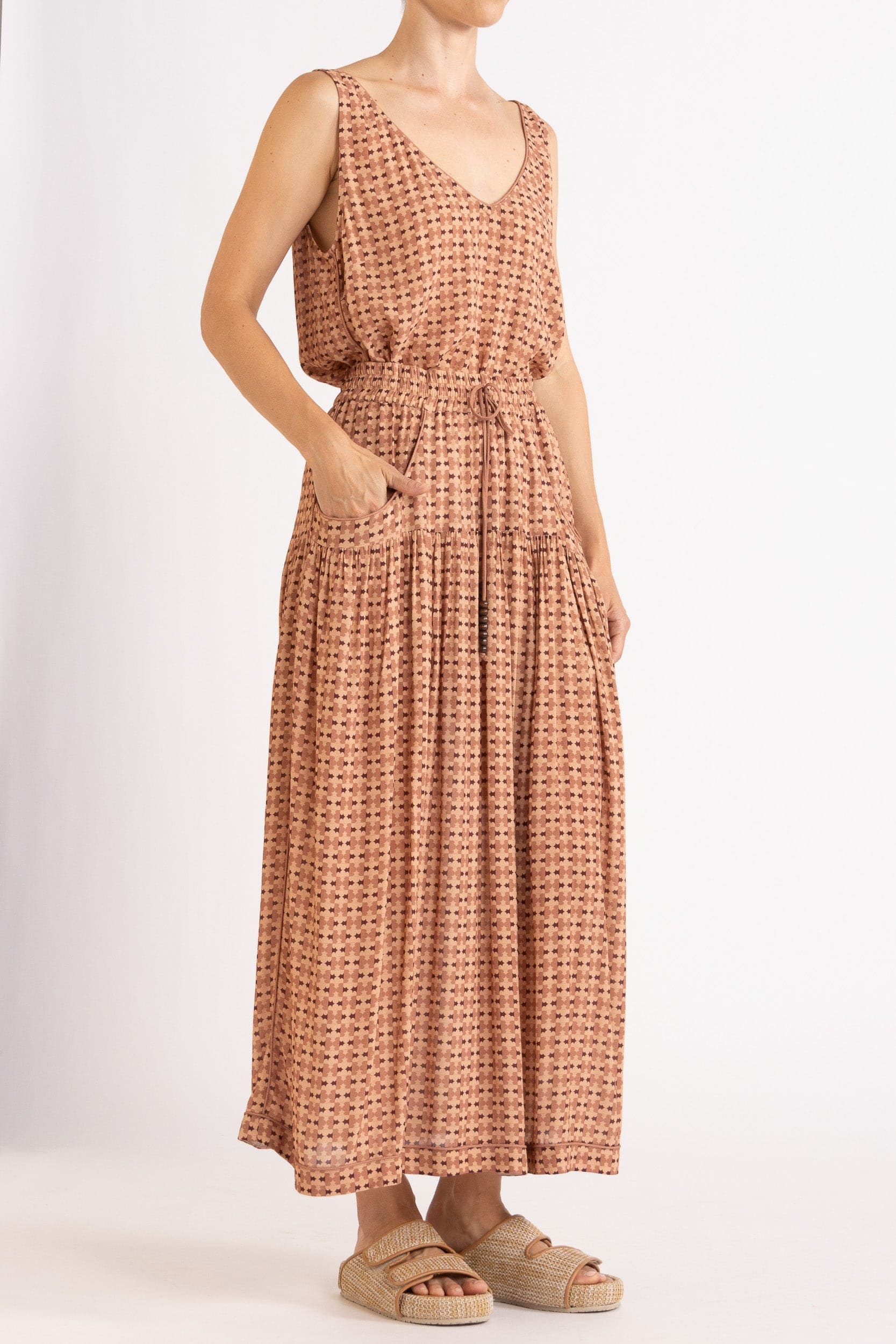 Model wearing peach print tank and skirt, front-side view